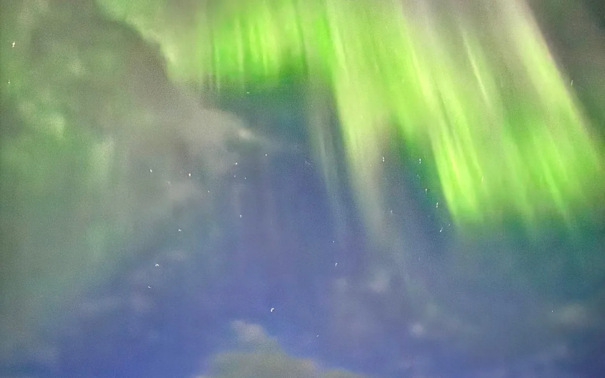The northern lights above a fjord near Tromso