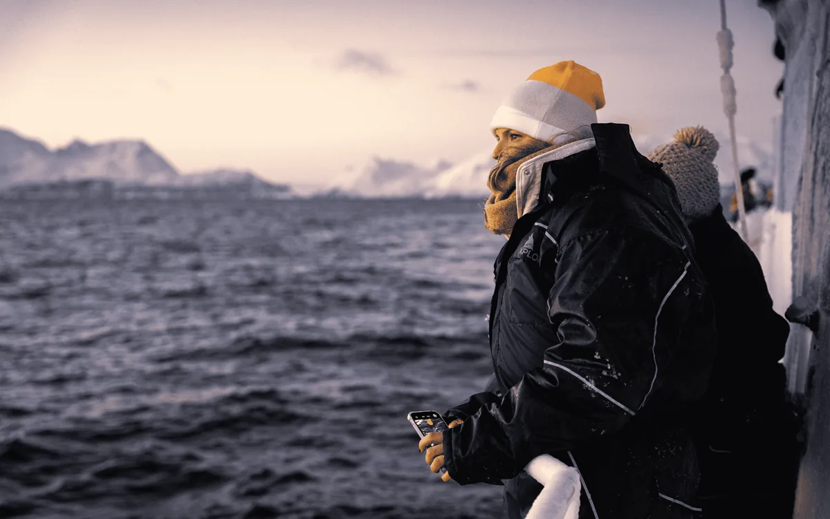 A passenger watching for whales from a boat near Tromso